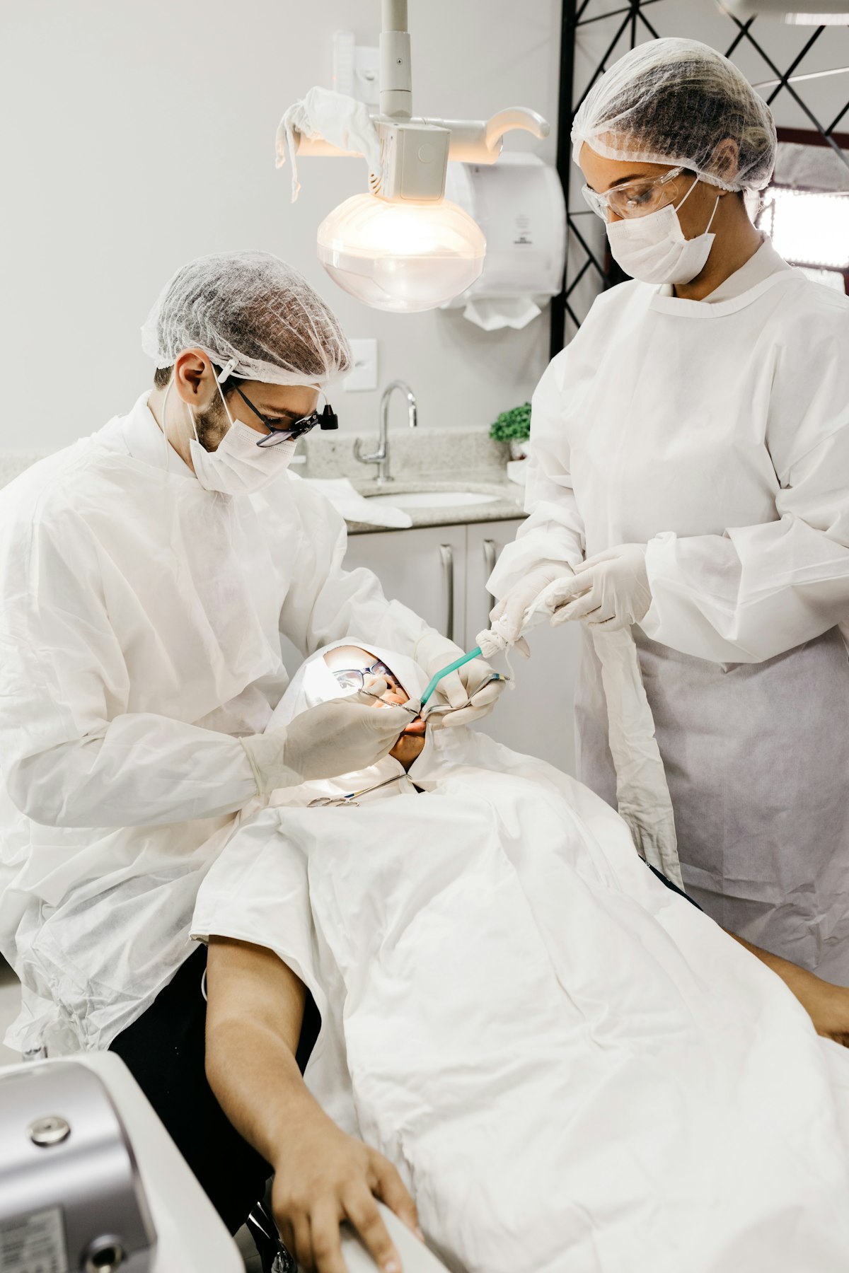 Dentist in white scrubs holding dental tools