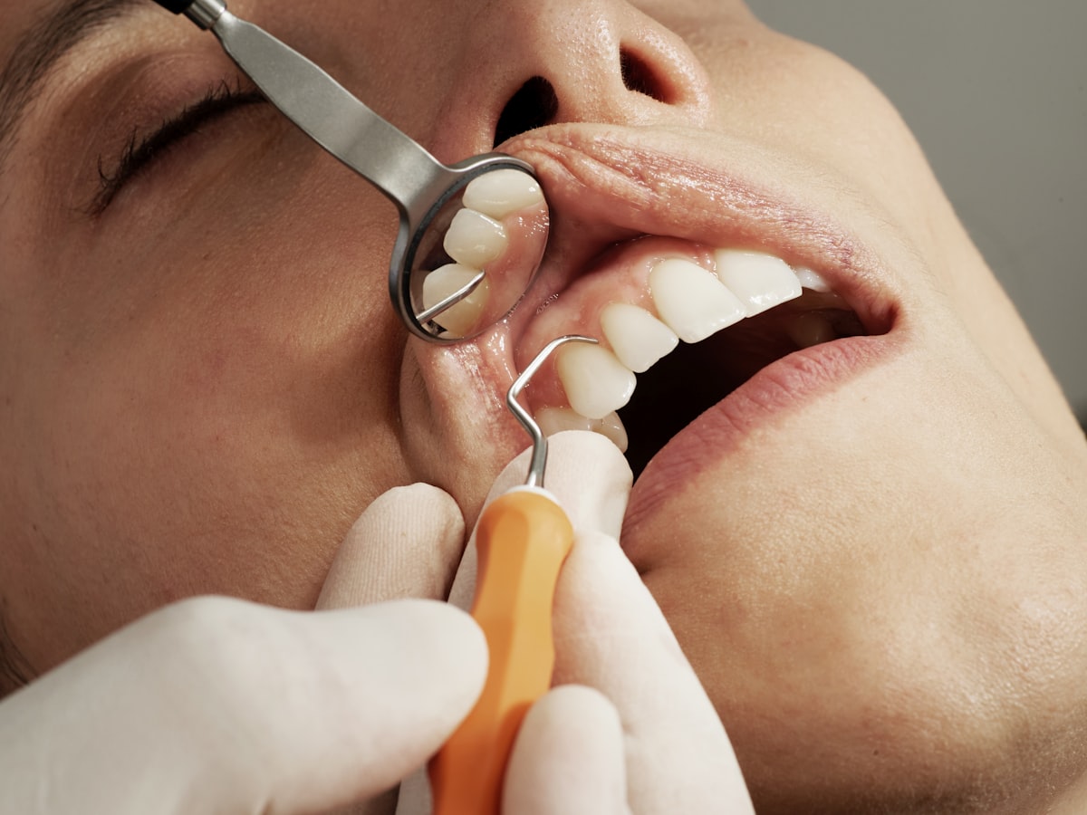 A dentist holding a dental mirror and tool