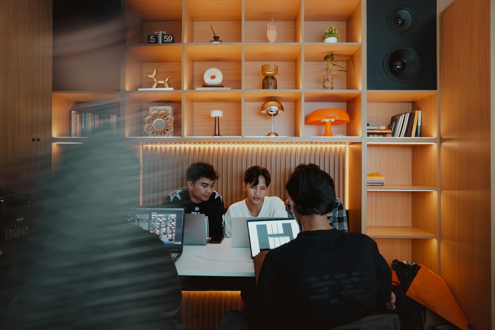 Three people collaborating on laptops at a table